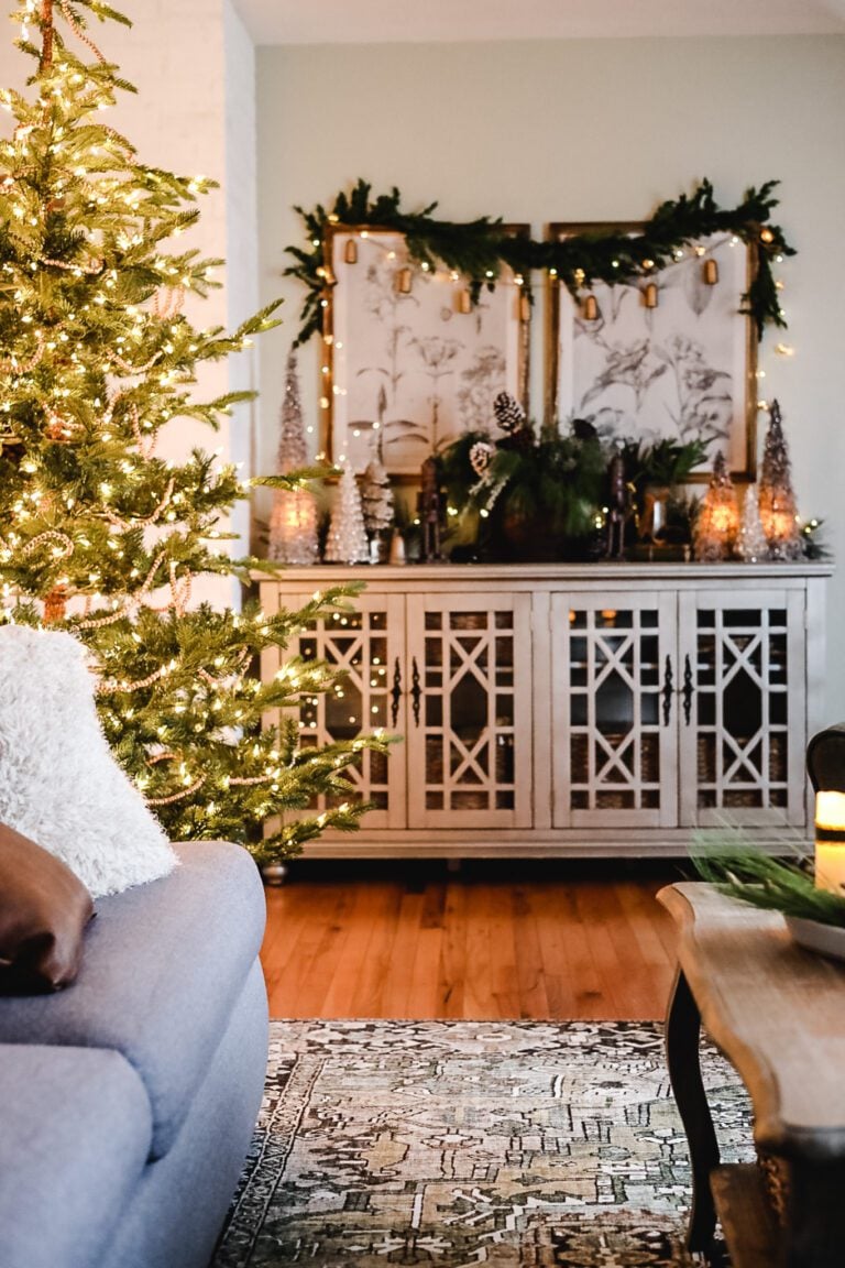 living room with christmas tree and decorated cabinet in the background