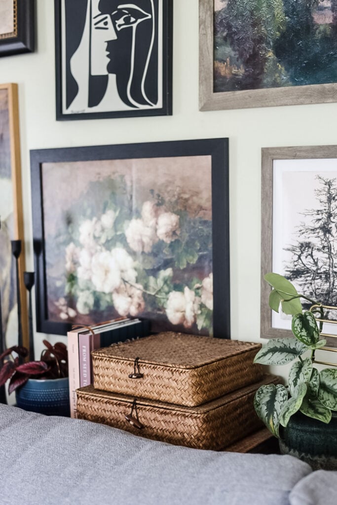 a styled sofa console table and art work hanging on a wall behind it