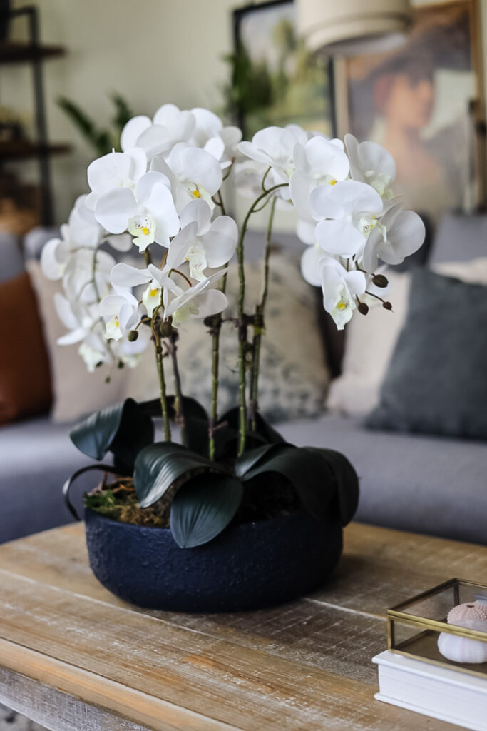 faux orchid arrangement on a wood coffee table