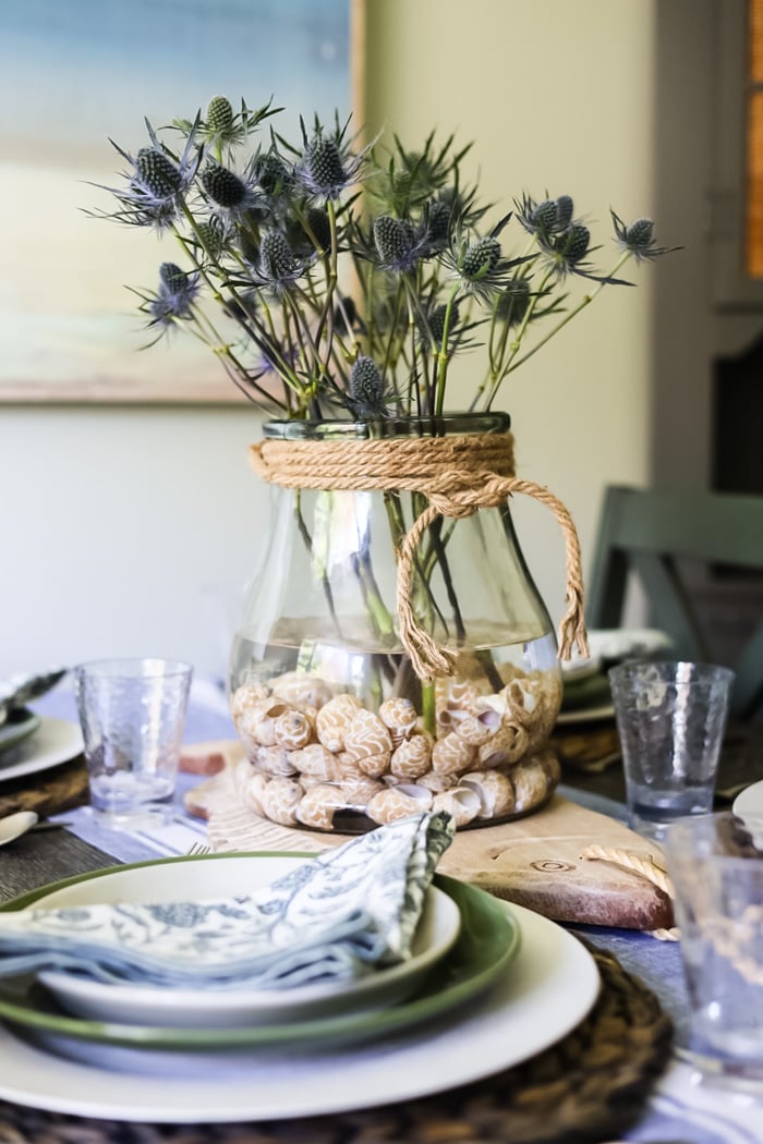 vase on table with sea holly and seashells