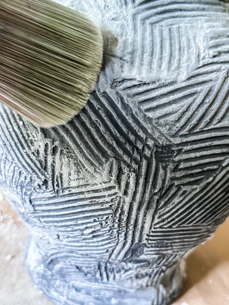 brushing off chalk dust from a vase