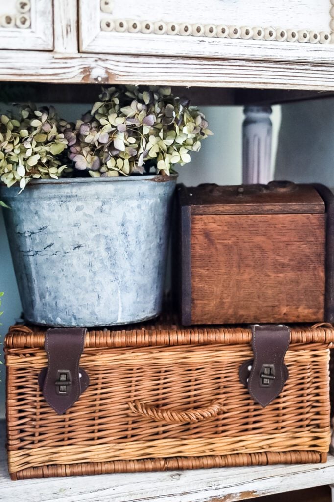 vintage pail with hydrangeas and wicker picnic basket