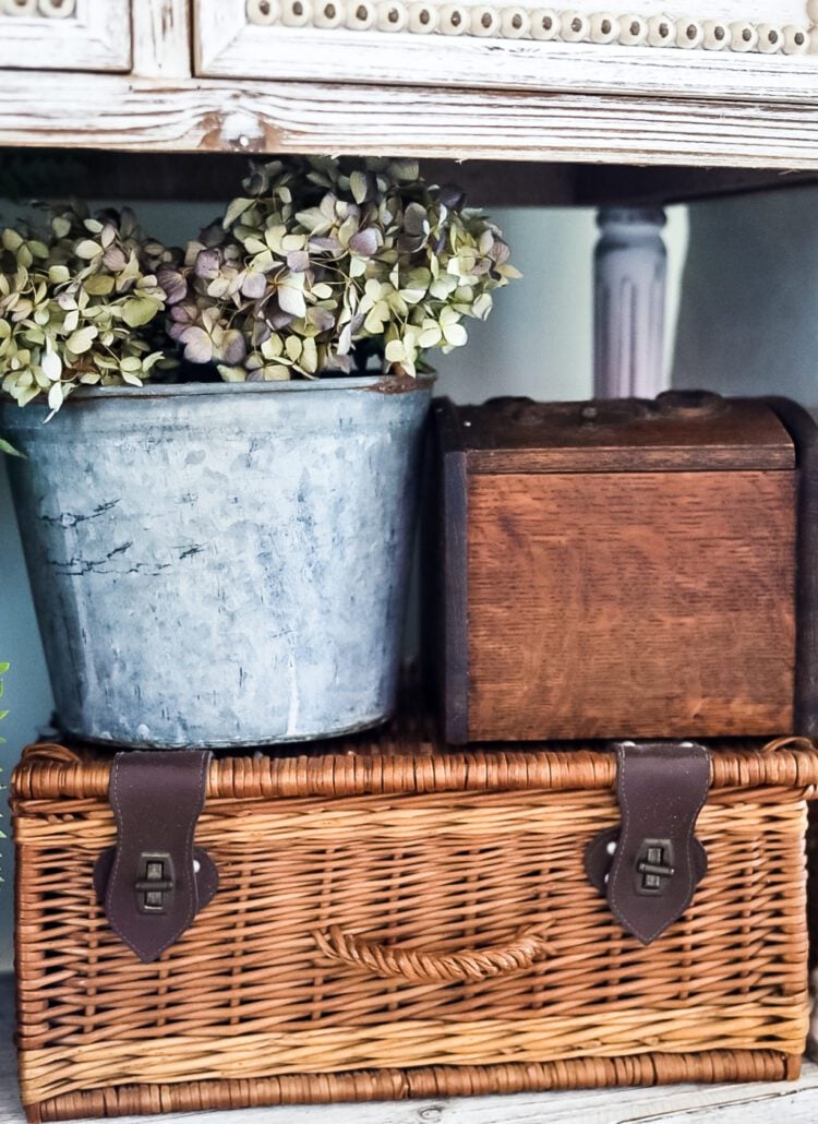 vintage pail with hydrangeas and wicker picnic basket